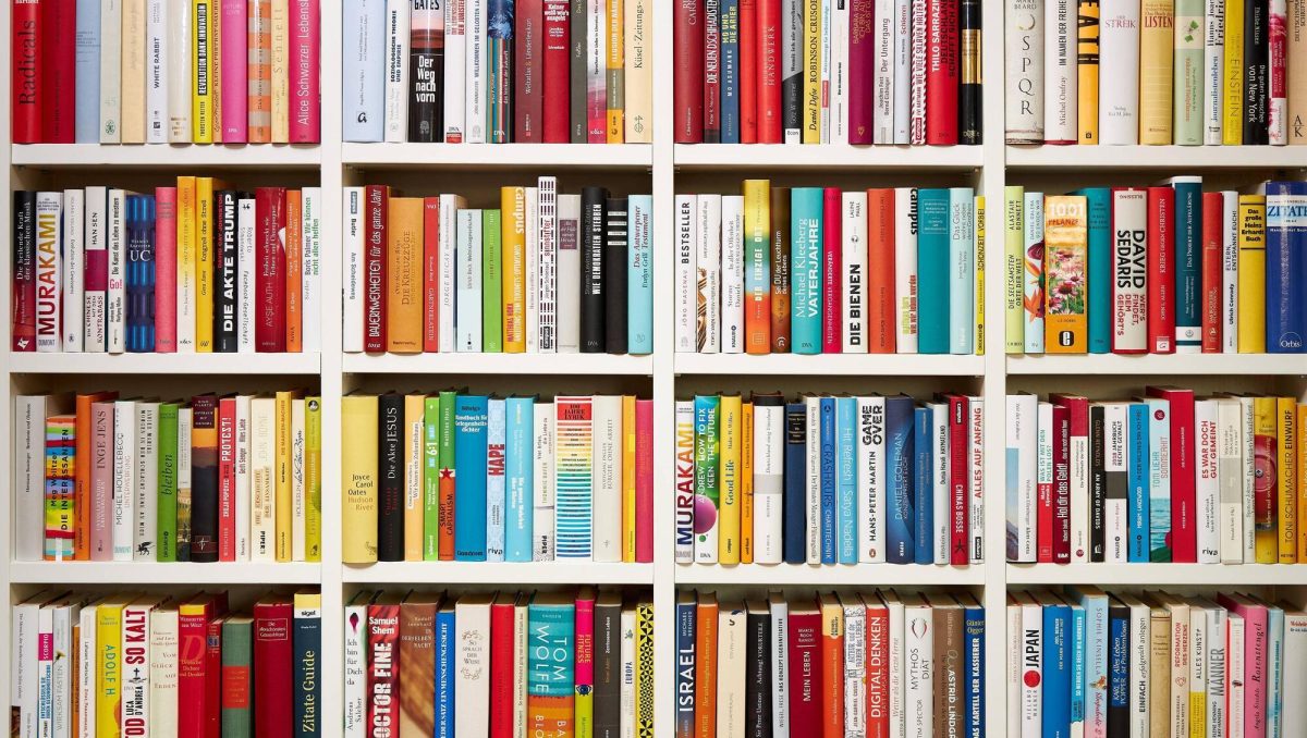A set of white shelves filled to bursting with books, many of which are better than the books we will be discussing in this article.